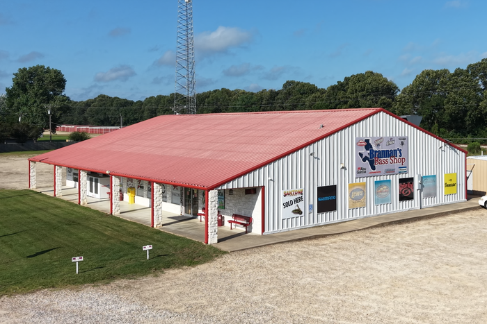 Brannans Bass  shop exterior shot with red roof, white walls, and brand advertisement on the walls.